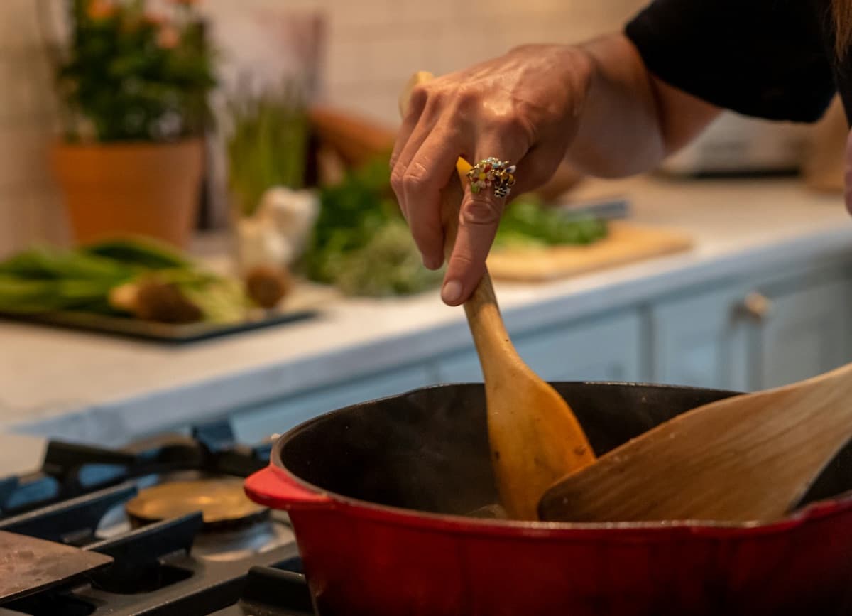 A pot of risotto being stirred with a wooden spoon